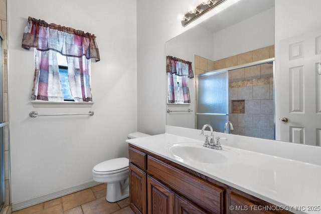 bathroom with tiled shower, vanity, and toilet