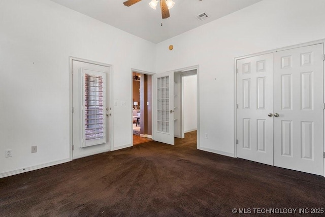 unfurnished bedroom with carpet floors, baseboards, a closet, and a ceiling fan