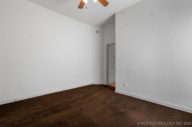 empty room with a ceiling fan, dark carpet, baseboards, and vaulted ceiling