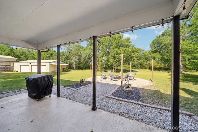 view of patio featuring a grill, an outbuilding, a fire pit, and view of wooded area