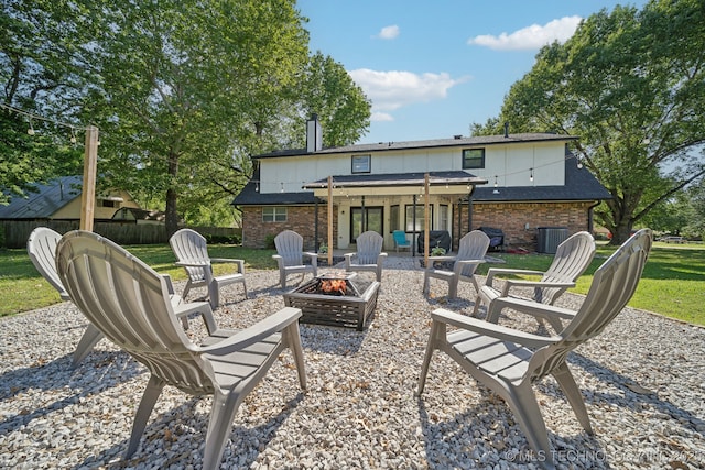 back of house featuring a fire pit and central air condition unit