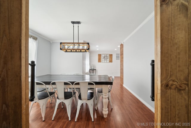 dining room with ornamental molding, baseboards, and wood finished floors