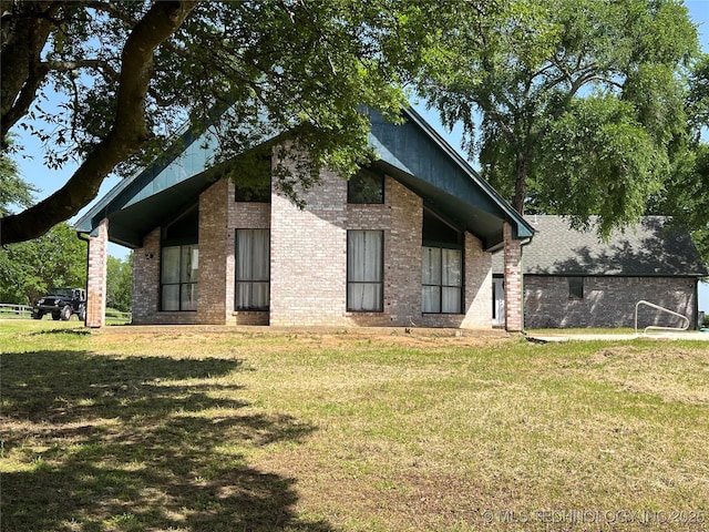 514 Lakeshore St, Durant, OK 74701 - rear view of house featuring a lawn and brick siding