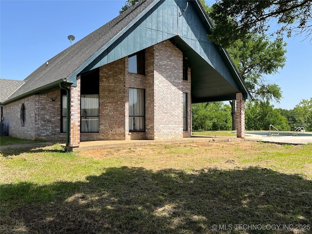 514 Lakeshore St, Durant, OK 74701 - rear view of house with a lawn, brick siding, a shingled roof, and central air condition unit
