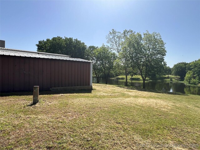 514 Lakeshore St, Durant, OK 74701 - view of grassy yard with a water view, a pole building, and an outbuilding