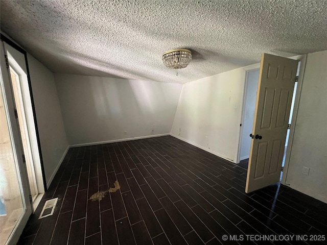 514 Lakeshore St, Durant, OK 74701 - unfurnished room with a textured ceiling, baseboards, and dark wood-type flooring