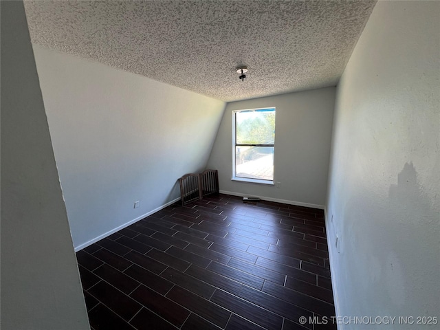 514 Lakeshore St, Durant, OK 74701 - spare room featuring a textured ceiling, vaulted ceiling, and baseboards