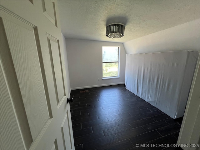 514 Lakeshore St, Durant, OK 74701 - bonus room featuring a textured ceiling, vaulted ceiling, baseboards, and a chandelier