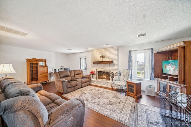 14516 E 36th St, Tulsa, OK 74134 - living area featuring a fireplace, healthy amount of natural light, a textured ceiling, and hardwood / wood-style floors