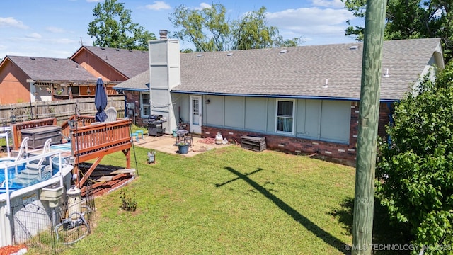 14516 E 36th St, Tulsa, OK 74134 - back of house with a shingled roof, board and batten siding, a chimney, brick siding, and a patio area