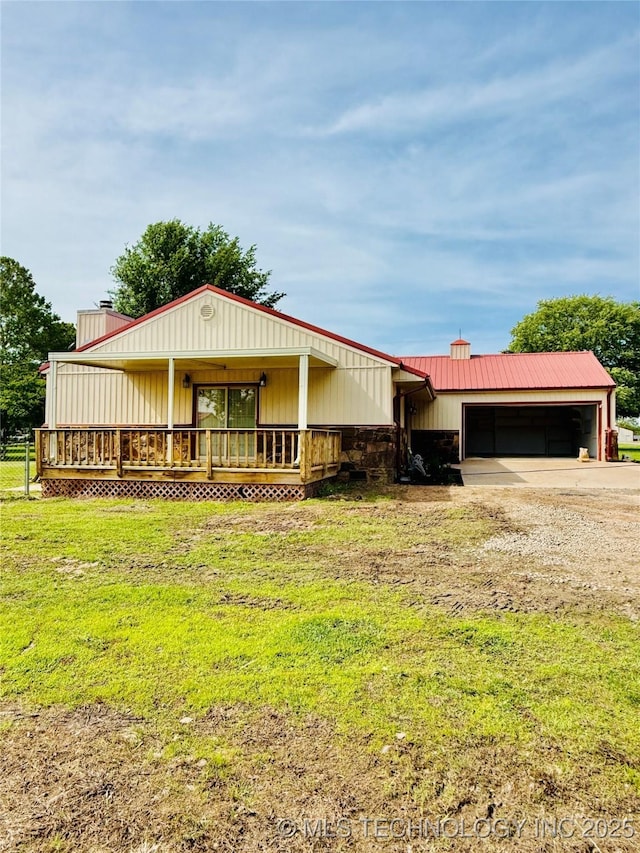 view of front of property with driveway, a chimney, a garage, a front lawn, and a deck