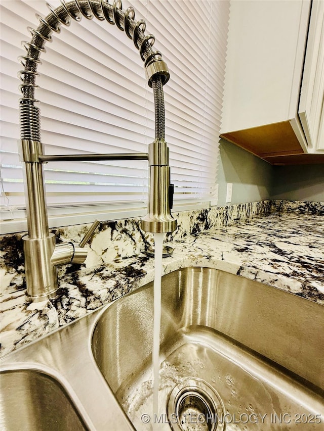 kitchen view of a sink and white cabinets