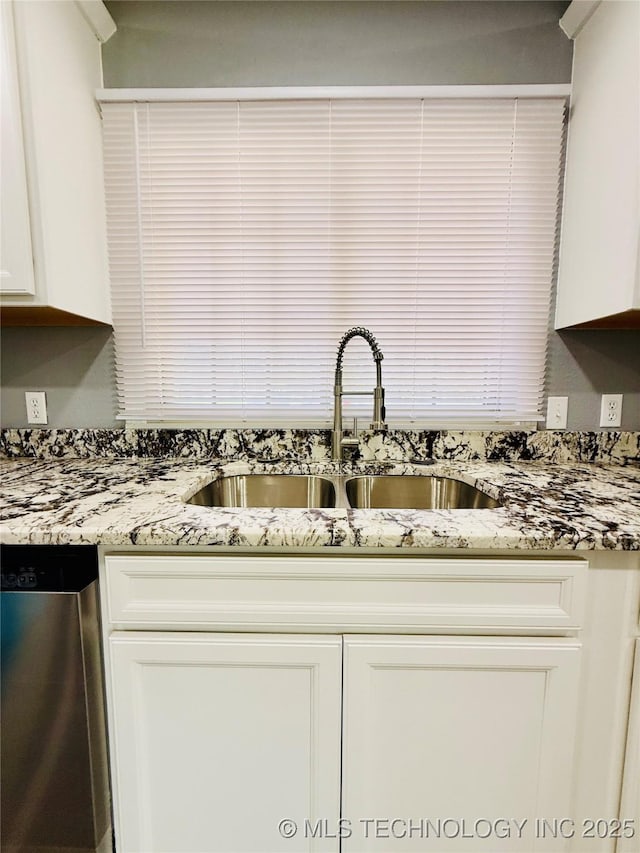 kitchen with dishwasher, a sink, white cabinetry, and light stone countertops