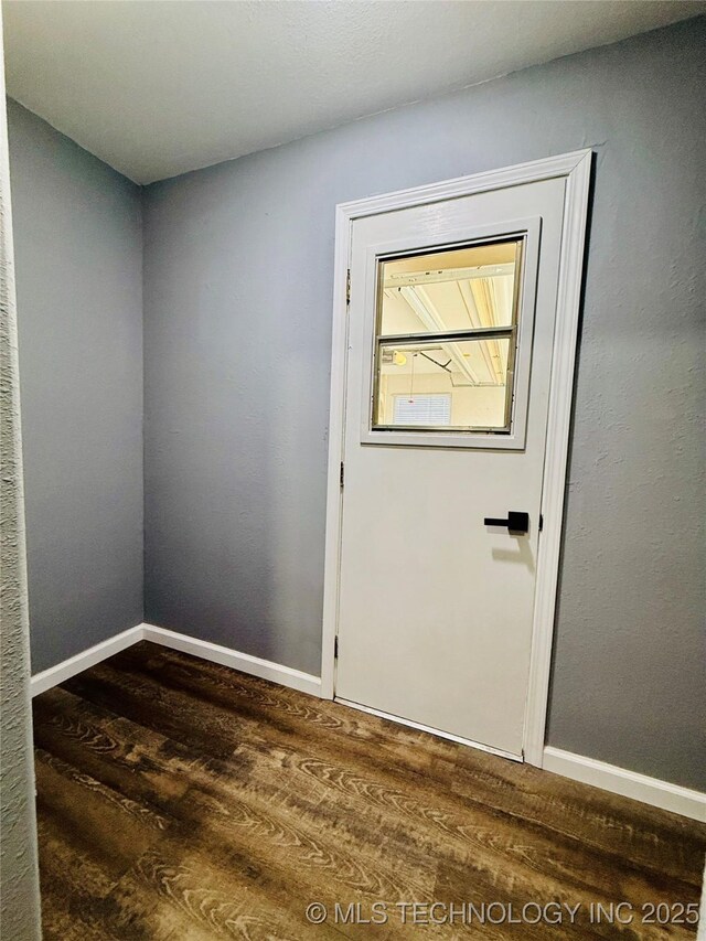 doorway to outside featuring dark wood-style floors and baseboards
