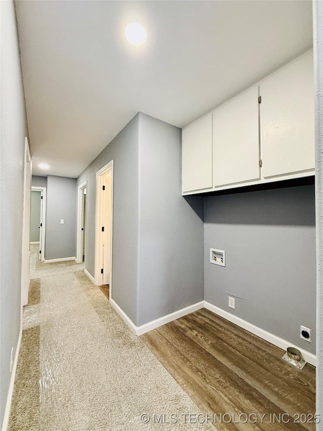 clothes washing area with washer hookup, cabinet space, baseboards, and wood finished floors