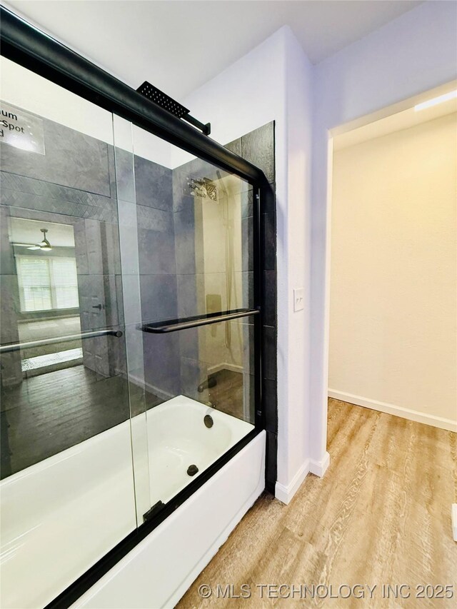 full bathroom featuring wood finished floors, shower / bath combination with glass door, and baseboards
