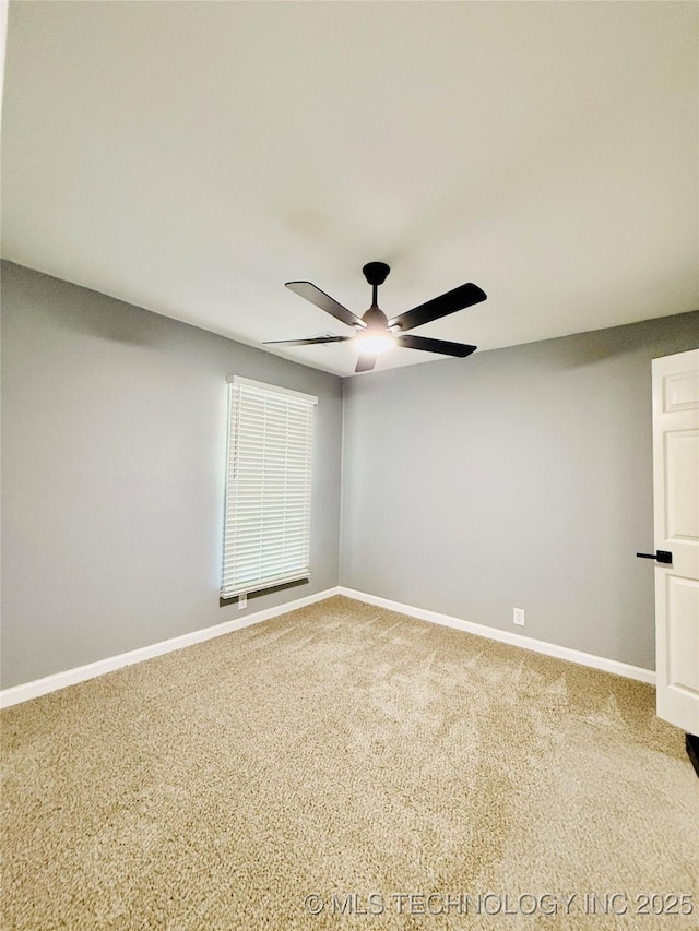 carpeted empty room featuring ceiling fan and baseboards