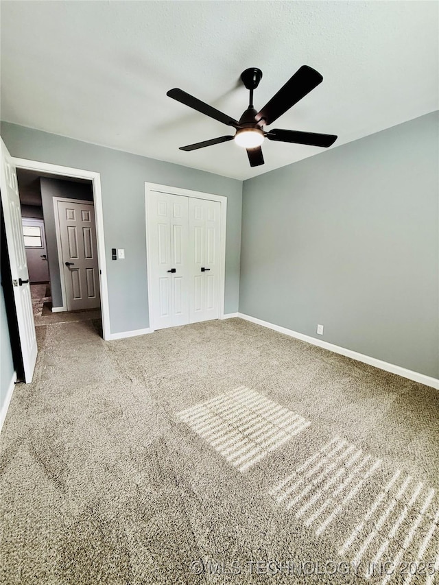 unfurnished bedroom featuring a closet, baseboards, carpet flooring, and a ceiling fan