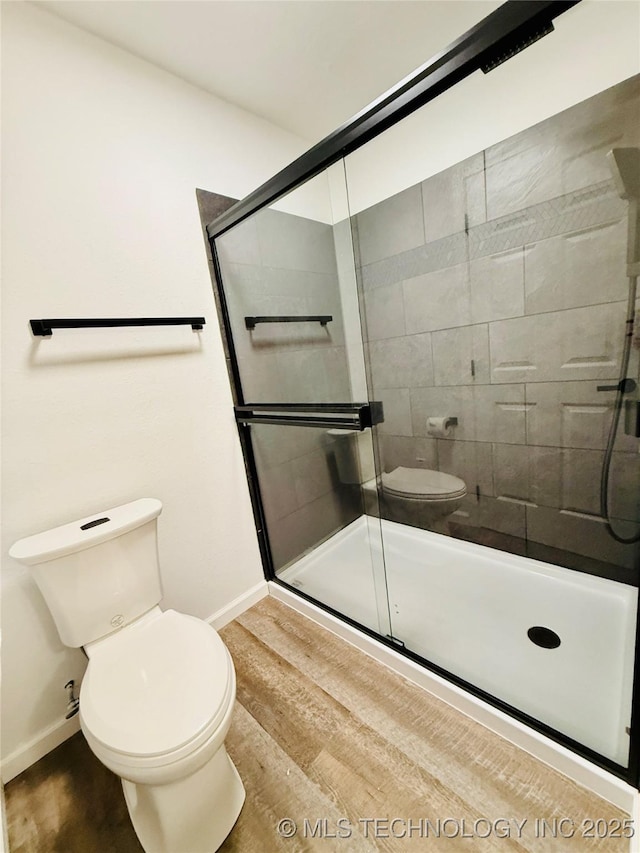 full bathroom featuring toilet, baseboards, and wood finished floors