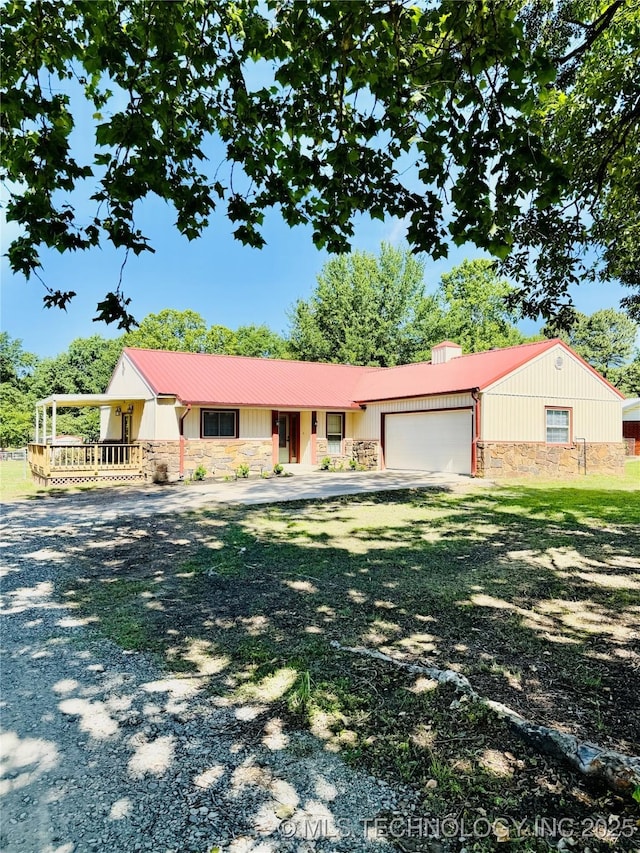ranch-style house featuring stone siding, a garage, covered porch, and a chimney