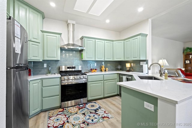 64 Floyd Everet, Colbert, OK 74733 - kitchen with appliances with stainless steel finishes, wall chimney exhaust hood, a peninsula, light wood finished floors, and recessed lighting