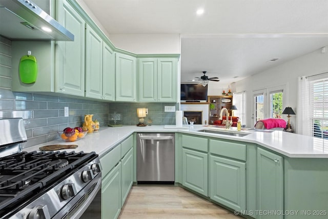 64 Floyd Everet, Colbert, OK 74733 - kitchen with appliances with stainless steel finishes, a sink, green cabinetry, a peninsula, and decorative backsplash