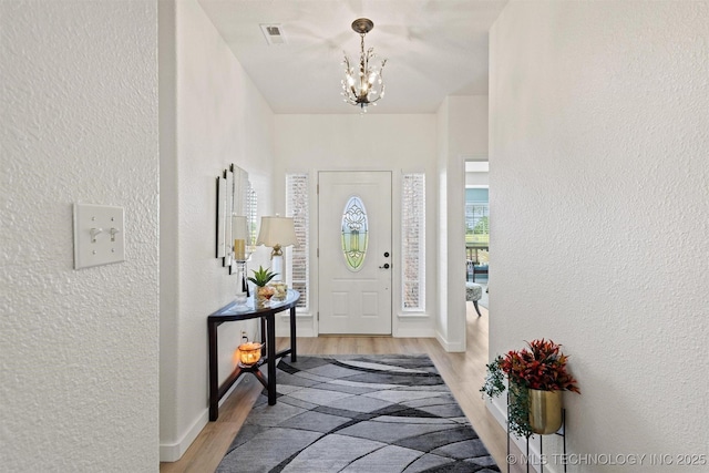 64 Floyd Everet, Colbert, OK 74733 - foyer entrance featuring a textured wall, a chandelier, light wood-style flooring, and baseboards