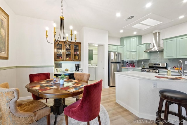 64 Floyd Everet, Colbert, OK 74733 - dining space with separate washer and dryer, light wood-type flooring, a chandelier, wainscoting, and recessed lighting