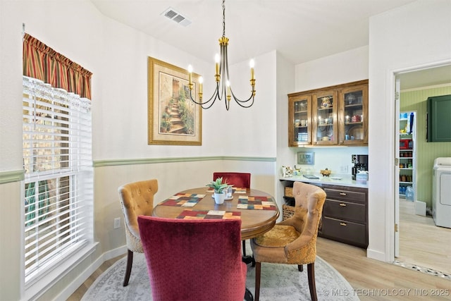 64 Floyd Everet, Colbert, OK 74733 - dining area featuring washer / dryer, light wood finished floors, and a chandelier