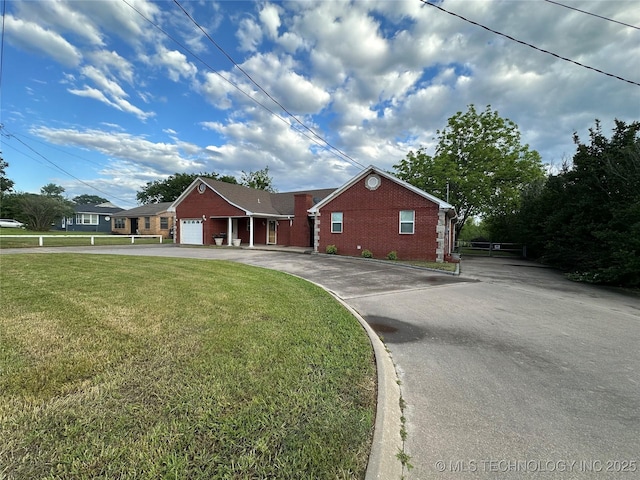 924 9th Ave SE, Ardmore, OK 73401 - ranch-style house featuring brick siding, asphalt driveway, a front yard, and a garage