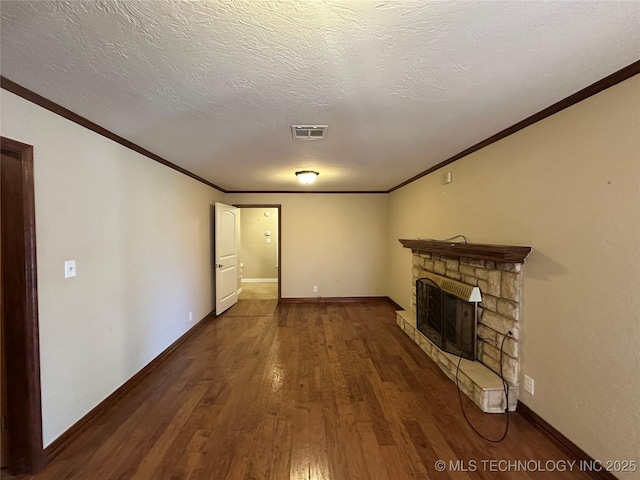 924 9th Ave SE, Ardmore, OK 73401 - unfurnished living room featuring crown molding, wood finished floors, a stone fireplace, baseboards, and a textured ceiling