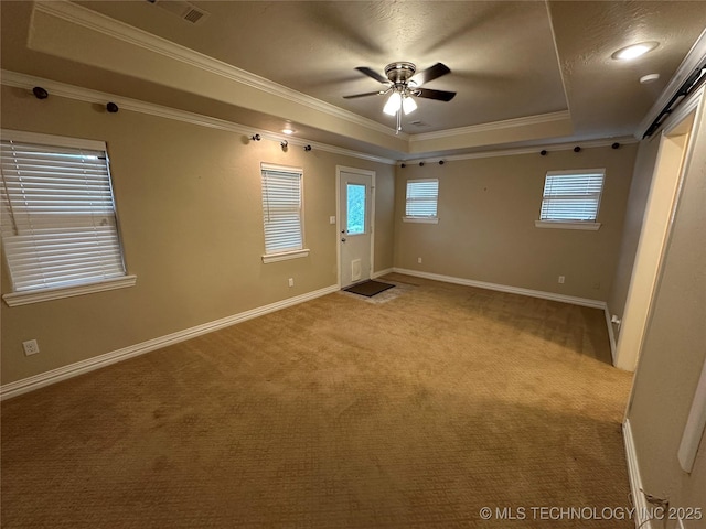 924 9th Ave SE, Ardmore, OK 73401 - unfurnished room featuring a tray ceiling, light carpet, a ceiling fan, crown molding, and baseboards