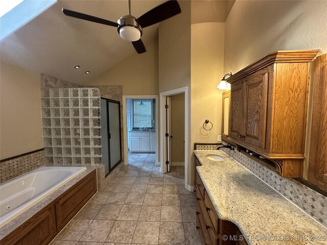 924 9th Ave SE, Ardmore, OK 73401 - bathroom featuring a ceiling fan, a shower stall, a garden tub, vanity, and baseboards