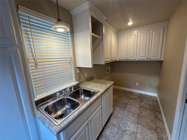 924 9th Ave SE, Ardmore, OK 73401 - kitchen with white cabinets, open shelves, baseboards, a sink, and decorative light fixtures