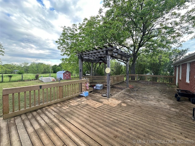 924 9th Ave SE, Ardmore, OK 73401 - wooden deck featuring a storage shed, a pergola, an outbuilding, and view of wooded area