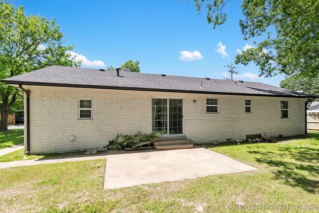 back of house featuring entry steps, a lawn, a patio, and brick siding