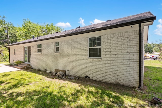 view of property exterior with a lawn, crawl space, brick siding, entry steps, and a patio area