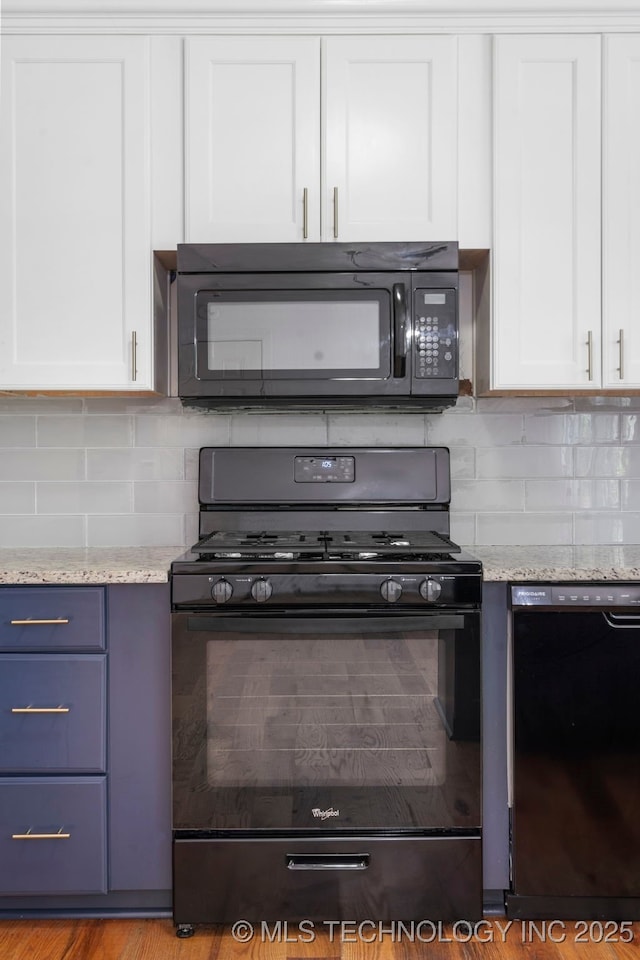 kitchen with black appliances, tasteful backsplash, white cabinetry, light stone counters, and blue cabinets