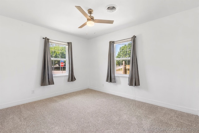 carpeted empty room featuring a ceiling fan and baseboards