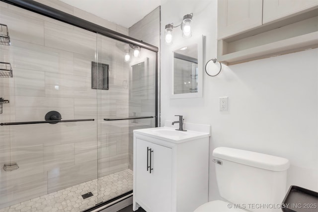 bathroom with toilet, a shower stall, and vanity