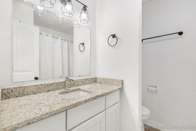full bathroom featuring toilet, vanity, and baseboards