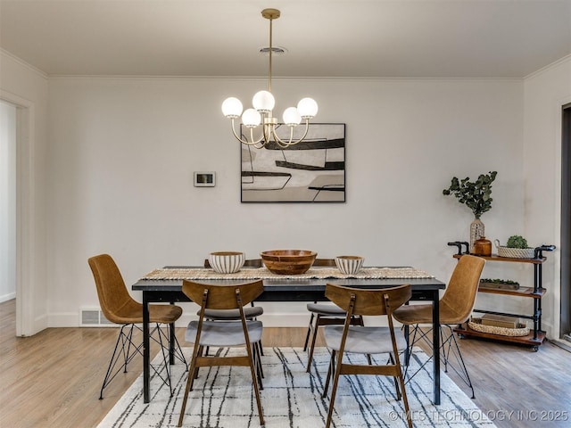 2528 E 57th St, Tulsa, OK 74105 - dining space featuring breakfast area, light wood finished floors, a chandelier, crown molding, and baseboards