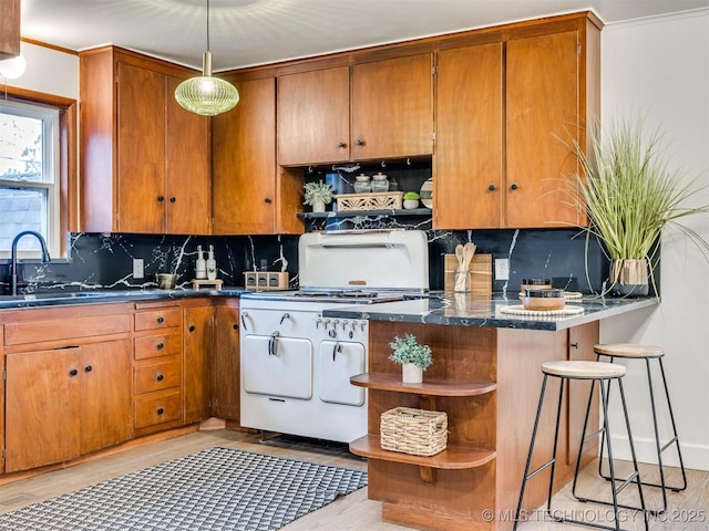 2528 E 57th St, Tulsa, OK 74105 - kitchen featuring open shelves, gas stove, a sink, light wood-type flooring, and decorative backsplash