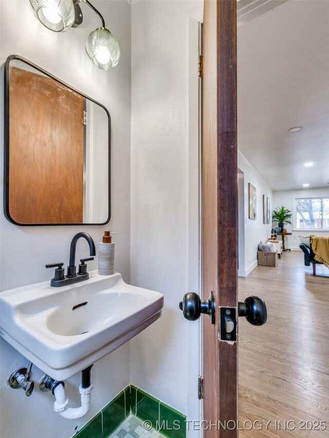 2528 E 57th St, Tulsa, OK 74105 - bathroom featuring wood finished floors, baseboards, and a sink