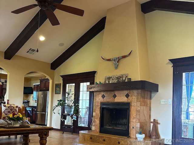 1216 N Oak Grove Rd, Drumright, OK 74030 - living room with beam ceiling, a tile fireplace, ceiling fan, high vaulted ceiling, and arched walkways
