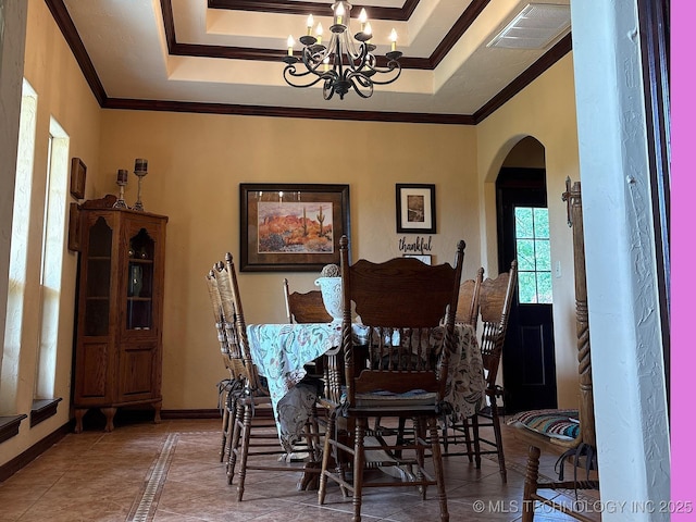 1216 N Oak Grove Rd, Drumright, OK 74030 - dining space featuring arched walkways, a chandelier, a raised ceiling, ornamental molding, and inlaid floor details