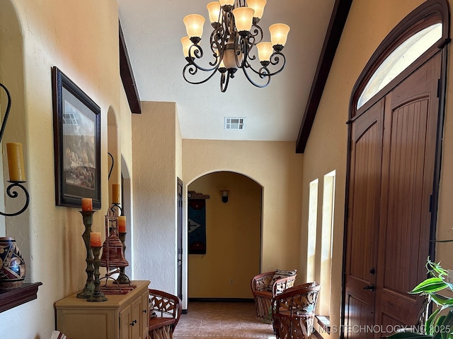 1216 N Oak Grove Rd, Drumright, OK 74030 - tiled entryway featuring arched walkways, a chandelier, a textured wall, and vaulted ceiling