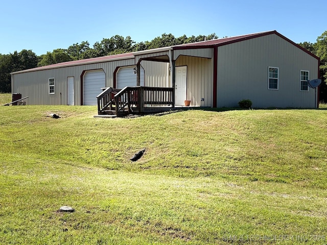 1216 N Oak Grove Rd, Drumright, OK 74030 - rear view of house with a garage, a lawn, and an outdoor structure