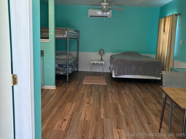 1216 N Oak Grove Rd, Drumright, OK 74030 - bedroom with an AC wall unit, wood finished floors, and a wainscoted wall