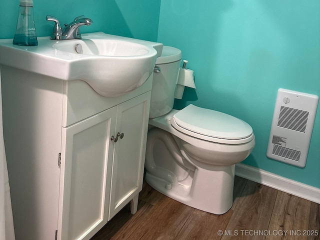 1216 N Oak Grove Rd, Drumright, OK 74030 - bathroom with wood finished floors, vanity, toilet, baseboards, and heating unit
